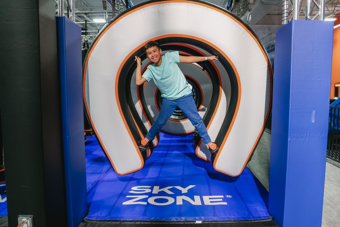 Final asset: a boy jumping through an inflatable Sky Zone tunnel obstacle