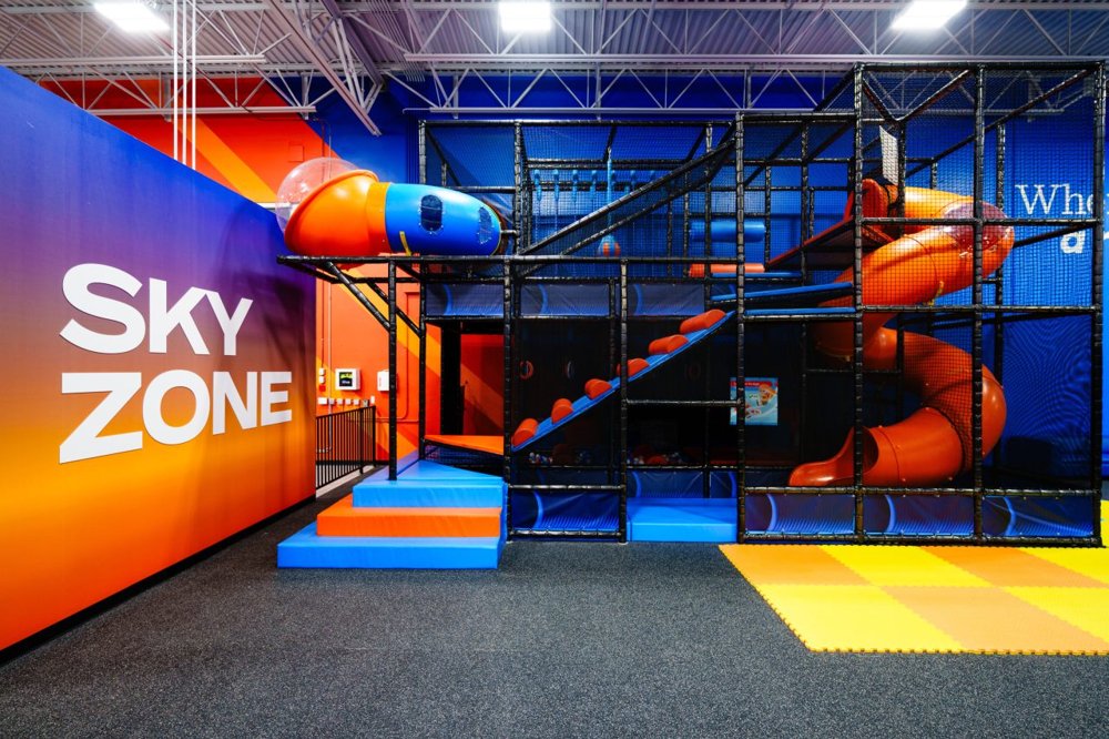 Sky Zone park interior featuring the refreshed orange and blue brand identity